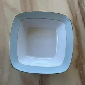 Vit serveringsskål i porslin med guldkant